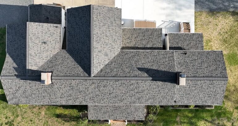 Aerial view of chimney and completed residential roof shingles