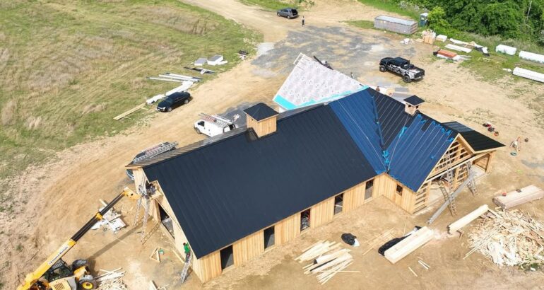 Aerial view of commercial metal roof installation in progress